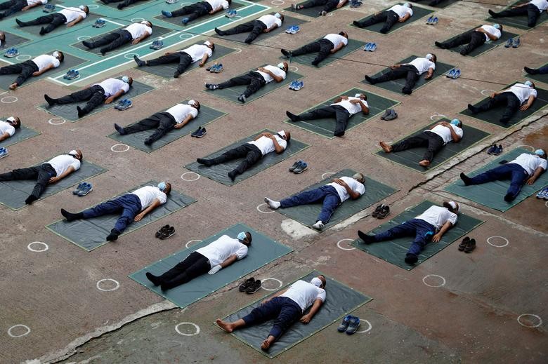 Members of the Bangladesh Police wear protective masks as they join a yoga session to boost their immune systems as the coronavirus outbreak continues, in Dhaka, Bangladesh. REUTERS/Mohammad Ponir Hossain  